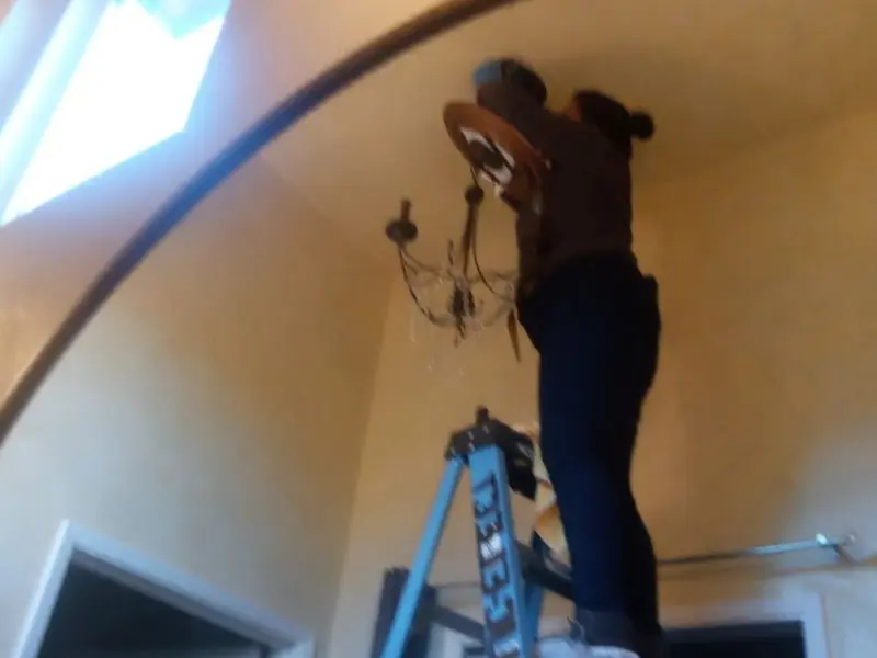 Electrician installing a chandelier in a East Porterville residence